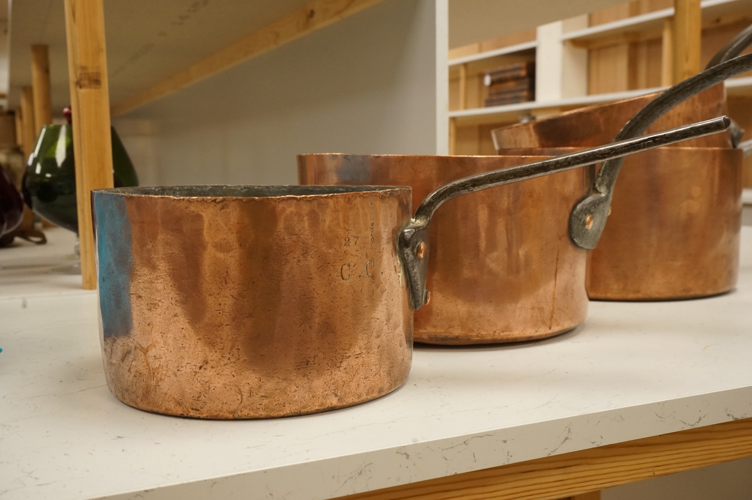 A graduated group of four large copper saucepans